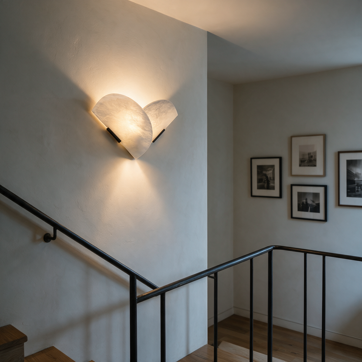 Aviva marble wall sconce washing warm light across a modern staircase landing