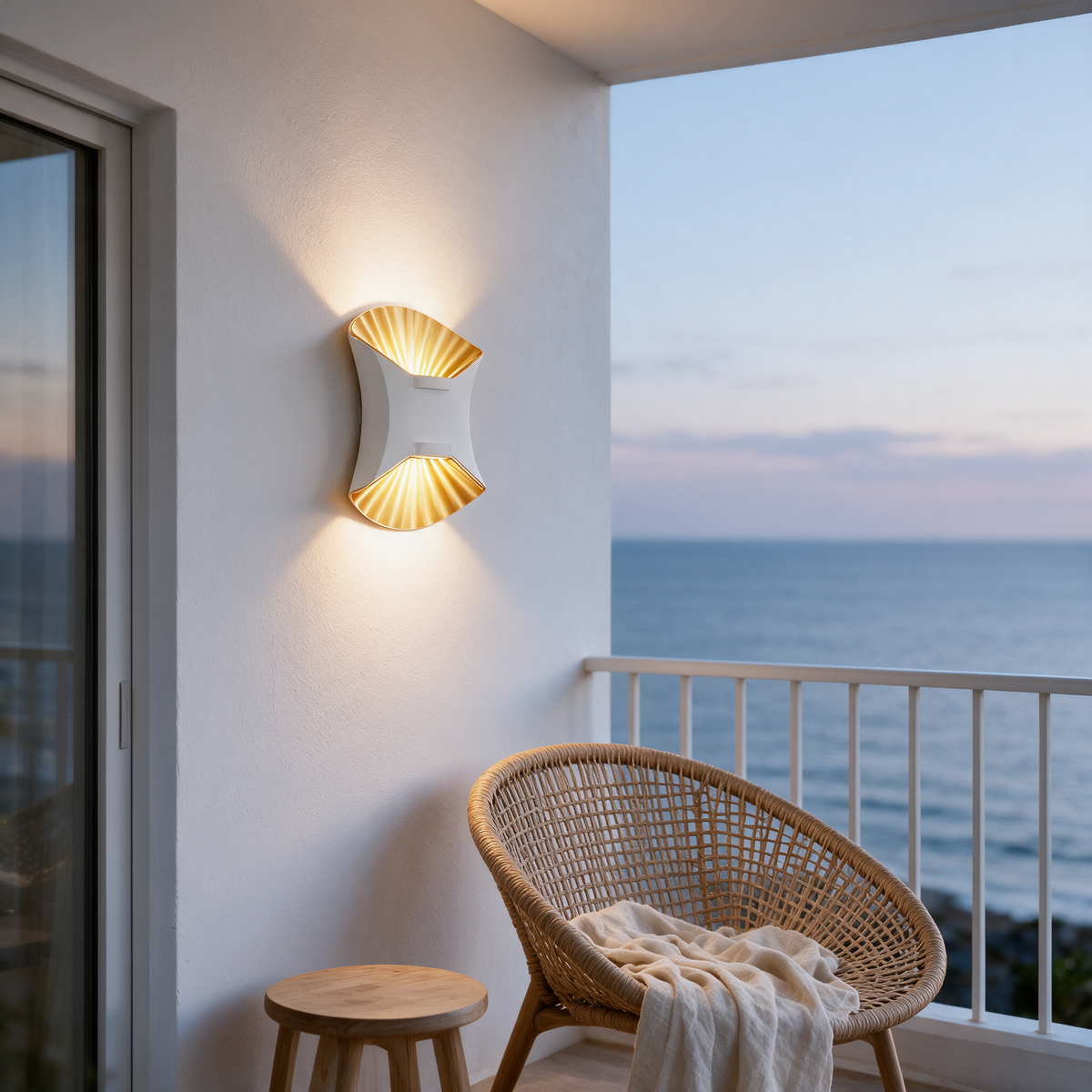 Solene white and gold wall light on a covered coastal balcony at dusk
