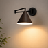 Soren Nordic Swing Arm Wall Sconce in Walnut with warm light, close-up against a plain wall