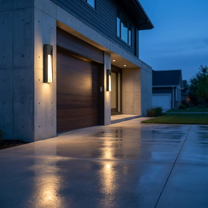 Aurelle wall light beside modern garage door at blue hour