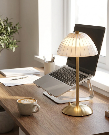 Elara brushed brass cordless table lamp on a home office desk