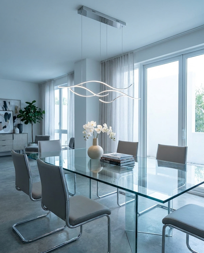 Ondeva chrome curved wave pendant over a glass dining table