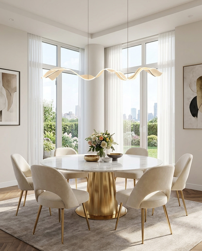 Cirelle gold ribbon wave pendant over a round dining table