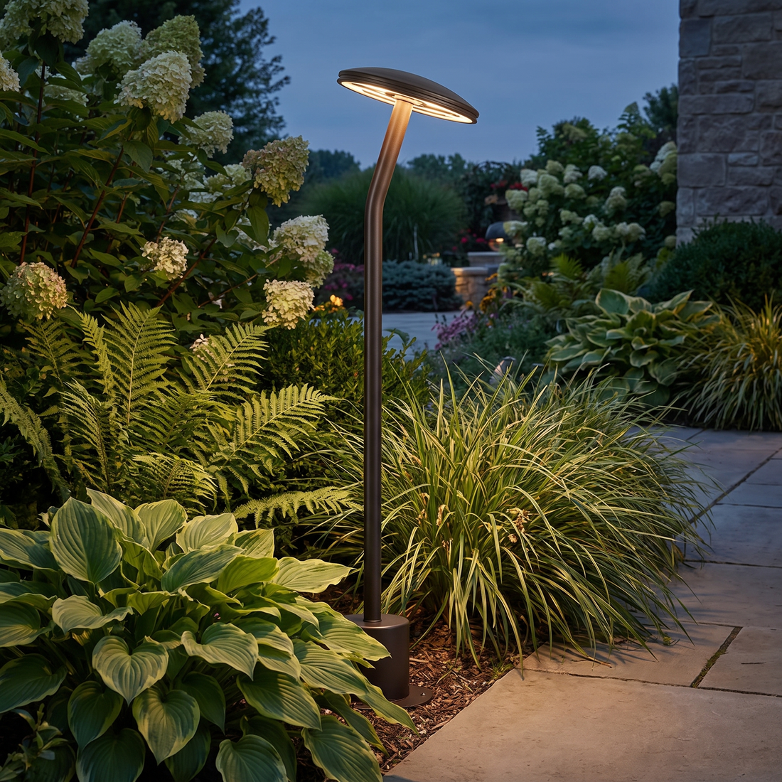 Bram bronze path light among lush border plantings