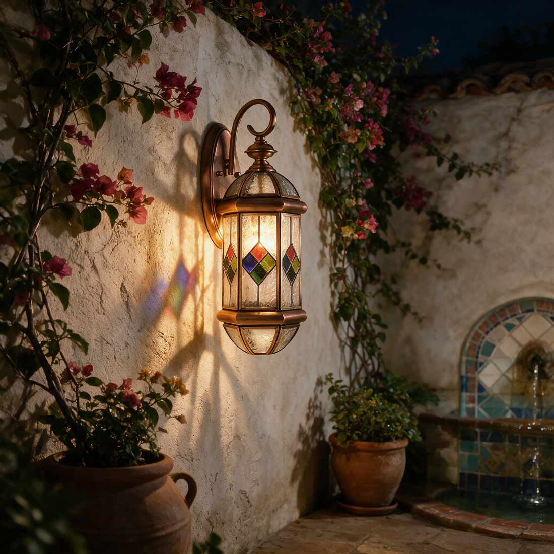 Kestrel copper lantern on a Mediterranean courtyard wall with bougainvillea at night