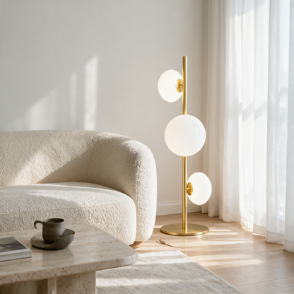 Juniper Floor Lamp in Gold and White beside a cream boucle sofa in a bright minimalist apartment