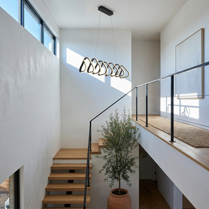 Salford black triangular acrylic LED pendant light in a double height stairwell