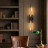 Verlaine black brass linear wall sconce in a refined study with dark oak shelving