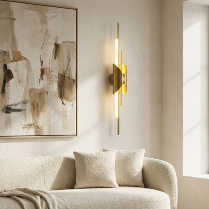 Verlaine natural brass linear wall sconce in a bright living room beside an abstract canvas