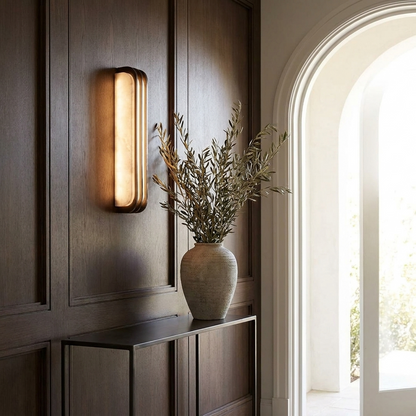 Marble vertical wall light glowing in a panelled entryway above a slim console table