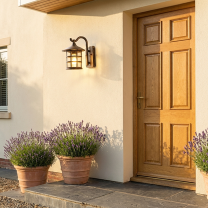 Antique bronze lantern outdoor wall light on cream render facade by oak door