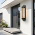 Linear black steel outdoor wall light on white render modern facade by pivot door