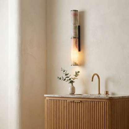 Black copper marble sconce beside a fluted vanity in a modern powder room