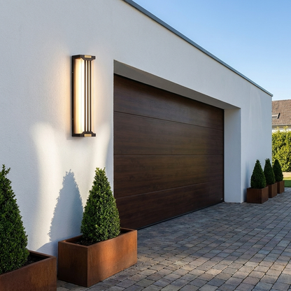 Up and down outdoor wall sconce on a white rendered garage exterior above a paved driveway