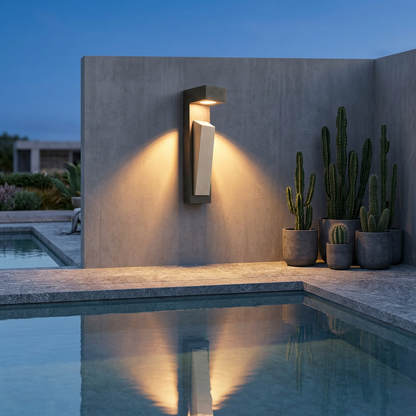 Black cement wall light glowing on poolside concrete wall in the evening