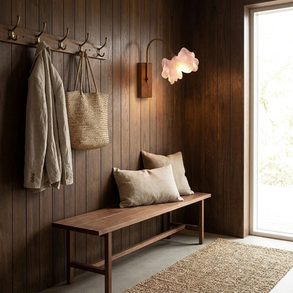 Cherry blossom sconce glowing in a panelled entryway with bench and coat hooks