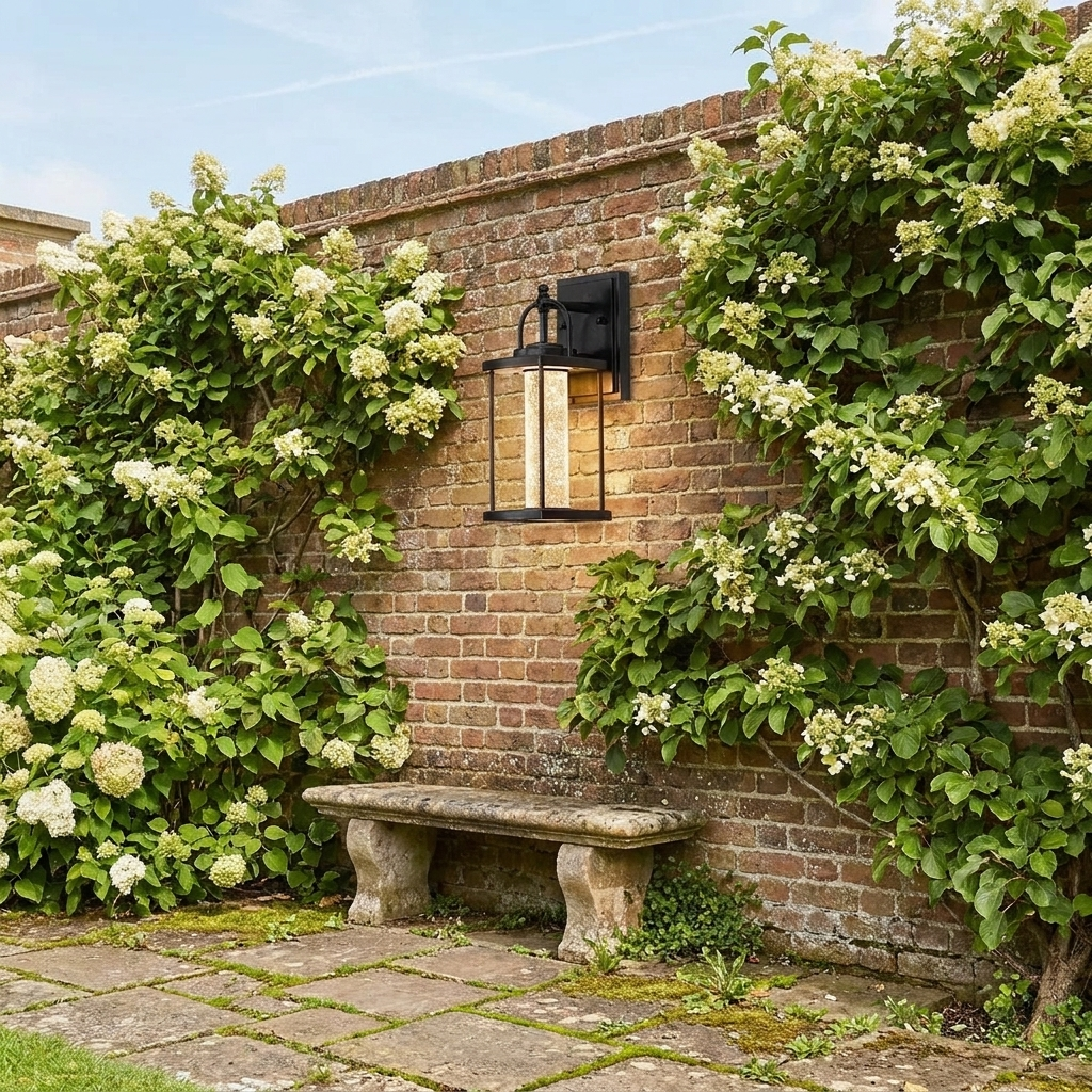Geometric lantern wall light on brick boundary wall with climbing hydrangea in daylight