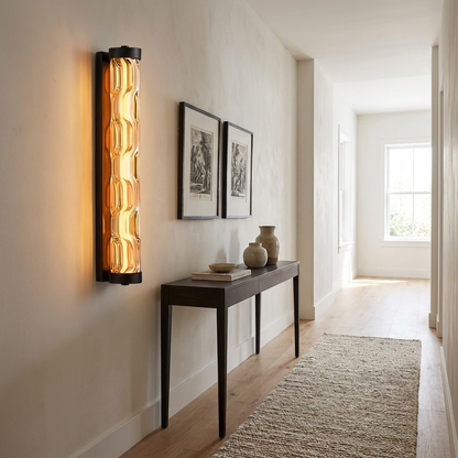 Amber glass linear sconce in a hallway with a wool runner and framed etchings