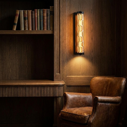 Amber glass wall light casting warm light above a desk in a dark oak study