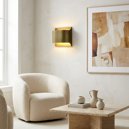 Sennen brass wall sconce wide round in a bright living room beside framed artwork