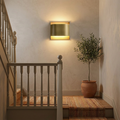 Sennen brass wall sconce wide round lighting a stairwell landing with a runner