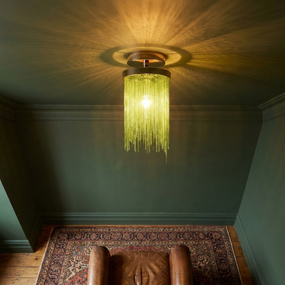 Odetta green metal tassel chandelier in a characterful living room with green wall