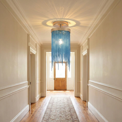 Odetta blue metal tassel chandelier in a long hallway with runner rug