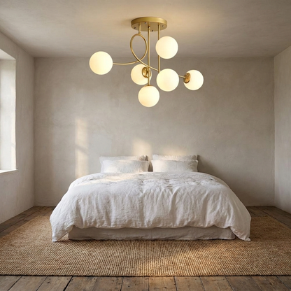 Lenore gold chandelier with milk white globes in a serene bedroom