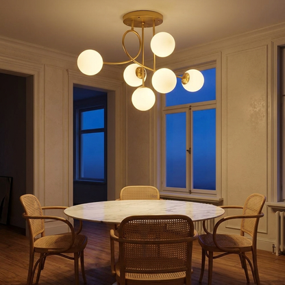 Lenore gold chandelier with milk white globes above a marble dining table