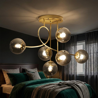 Lenore gold chandelier with smoke grey globes in a moody bedroom