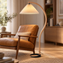 Caprani Beech Wood Linen Floor Lamp with Beige shade, close-up over a lounge chair