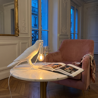 Corbeau white upright raven table lamp in a Parisian reading corner
