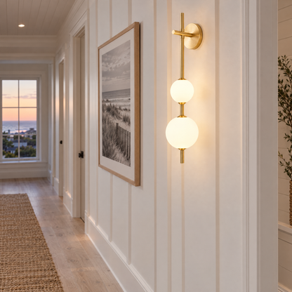 Kaskade globe wall sconce in brass with 3 globes in a Hamptons shingle-style beach house hallway