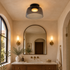 Tiera Layered Glass Ceiling Light, Single Smoke grey, in a Southern California Spanish bungalow bathroom with a vanity and arched mirror