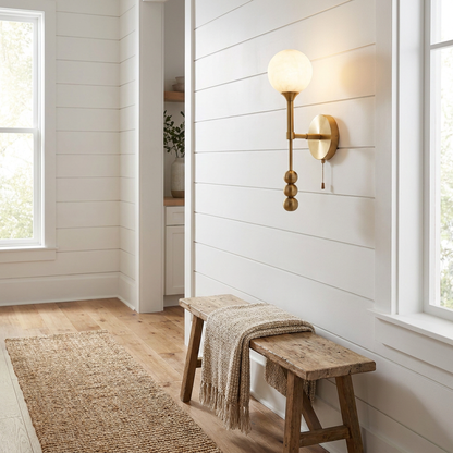 Isaure brushed brass wall sconce on a white shiplap hallway wall of a modern farmhouse