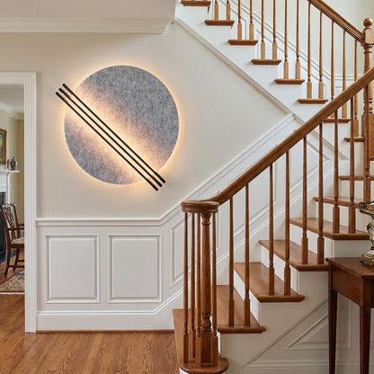 Aurore grey wall sconce in the entry foyer of a colonial style home with white wainscoting and a staircase