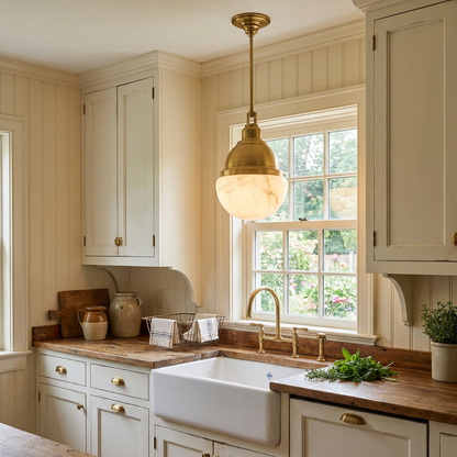Gisele brass pendant light over a farmhouse sink in a cottage kitchen