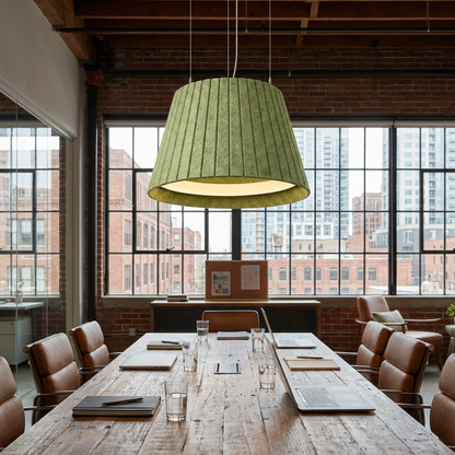 Calma green pendant light over a long conference table in a downtown office