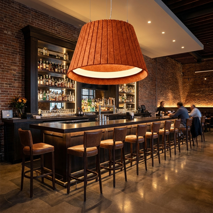 Calma orange pendant light over the bar of a modern American restaurant