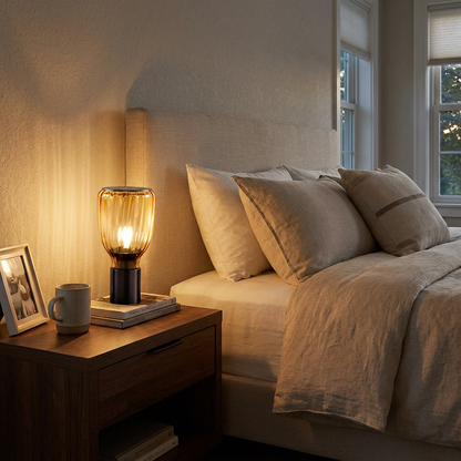 Verra amber table lamp on a nightstand beside a bed in a transitional suburban bedroom