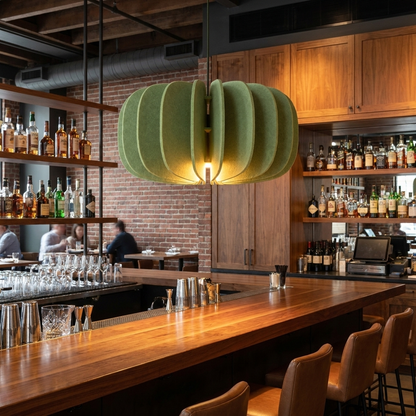 Lamelle disc sage green pendant light over the bar of a modern American restaurant