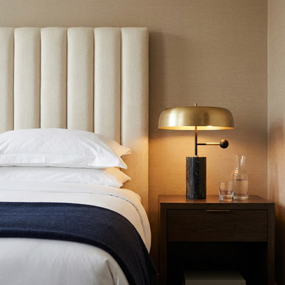 Barclay marble table lamp with gold dome shade on a nightstand in a boutique hotel room
