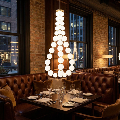Nacre teardrop shaped pearl chandelier over a booth in an upscale restaurant