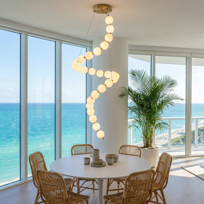 Nacre tall spiral pearl chandelier over a dining table in a Miami condo