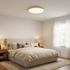 Lamina ultra thin round white LED flush mount ceiling light in a suburban bedroom