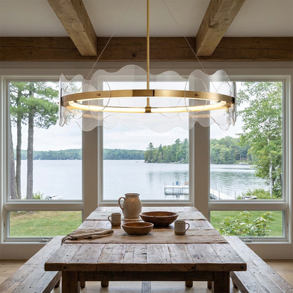 Rivage round LED chandelier over a dining table in a lake house