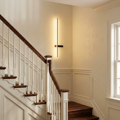 Stelo slim vertical black linear LED wall sconce on a staircase wall