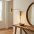 Swivo plug in swing arm wall lamp in brushed gold in an entryway