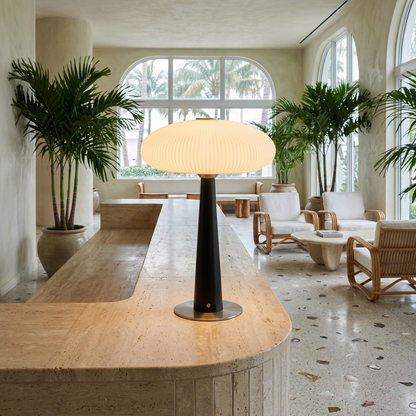 Quintia fluted glass rechargeable LED table lamp on a hotel lobby reception desk