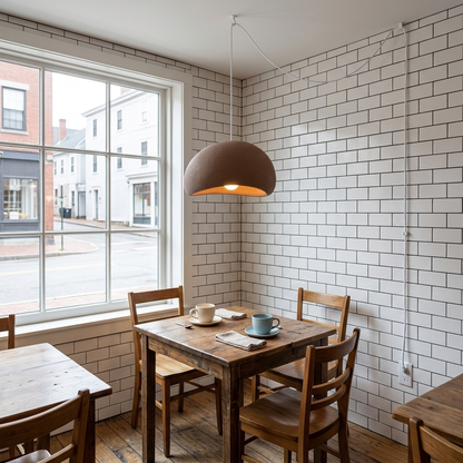 Thessaly cloud plug-in swag pendant light in Brown over a window table in a small cafe